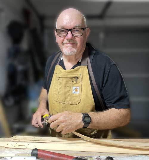 man standing in workshop making belts