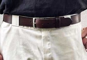 man in white pants with classic dark brown belt